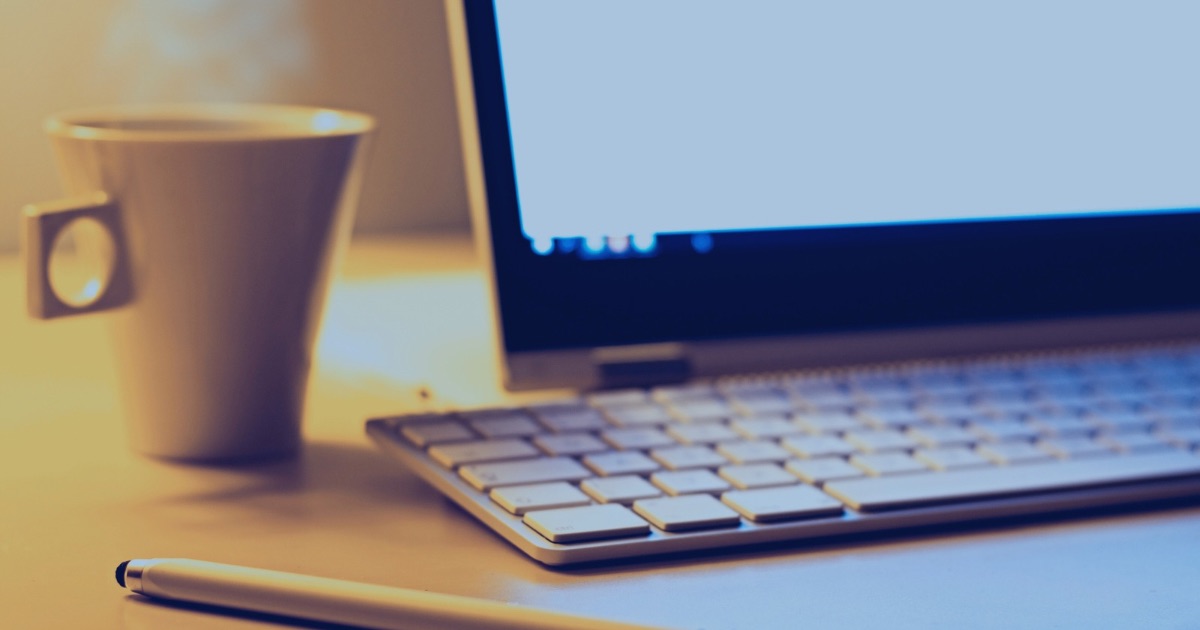 デスク上にPCとマグカップが置かれた、旅行あとがき用のアイキャッチ画像